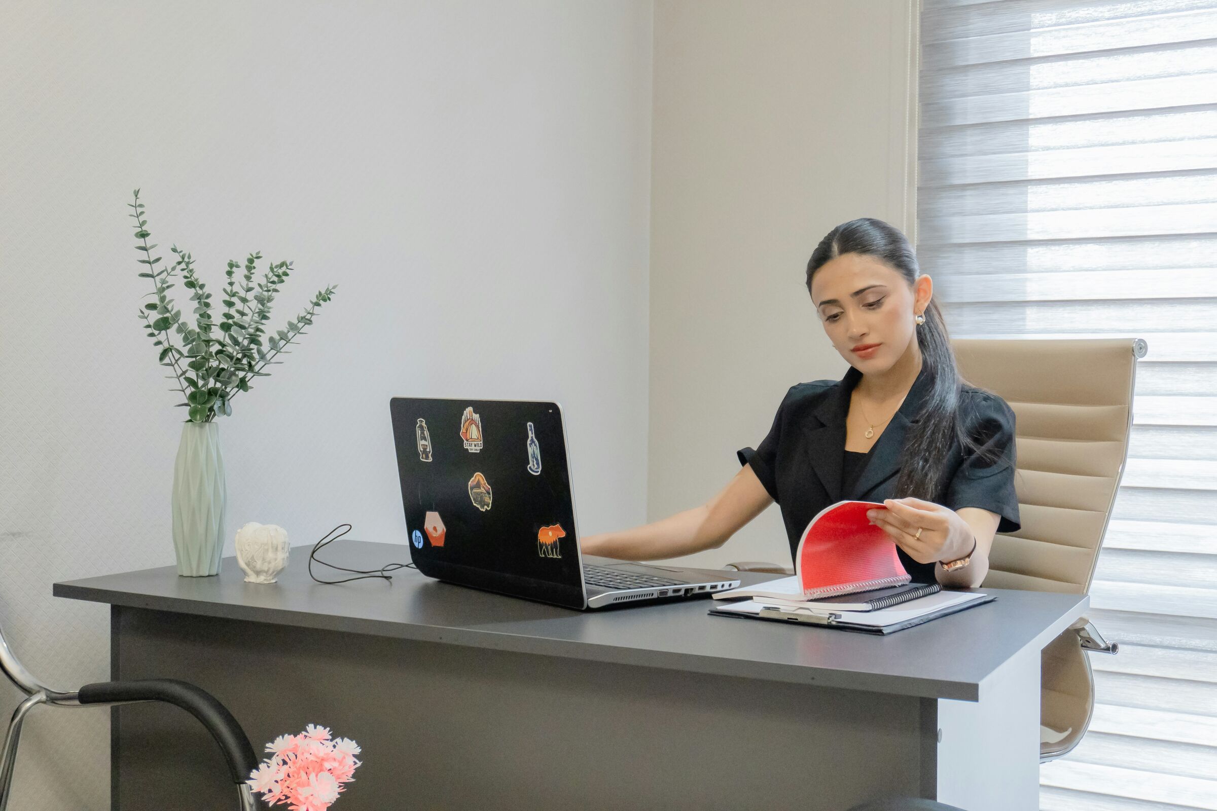 Professional reviewing documents at her laptop